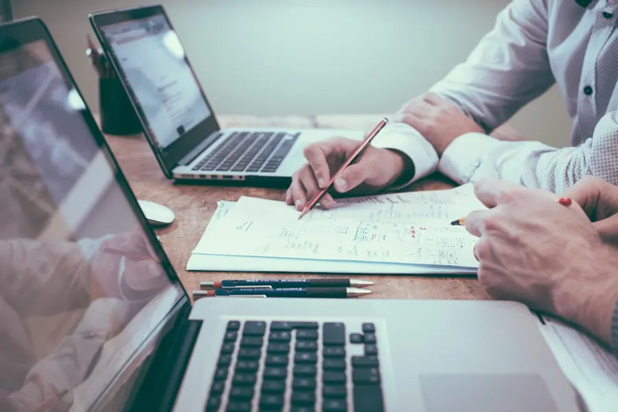 Accountant reconciling accounts on a laptop with handwritten working notes