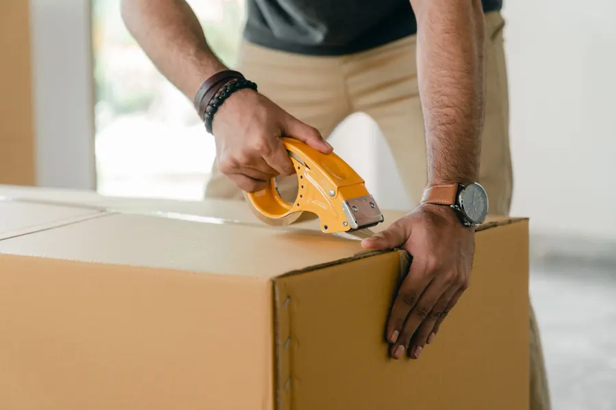 E-commerce seller taping a shipment box for dispatch
