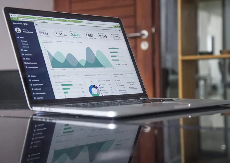 Laptop showing financial performance charts during a system migration review